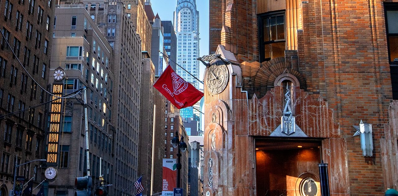 Cornell image Building along a street in New York City with the Chrysler Building in the background.